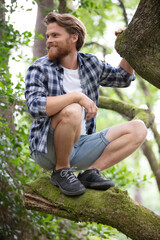 handsome man hiking climbing tree