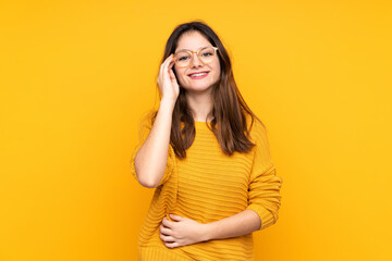 Young caucasian woman isolated on yellow background with glasses and happy