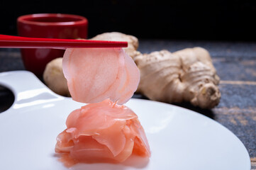 Asian food, eating of pink sliced pickled ginger roots