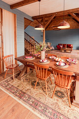 cozy all wooden interior of a country house in a wooden design. spacious living room with kitchen area with large windows. bedroom on the second floor.