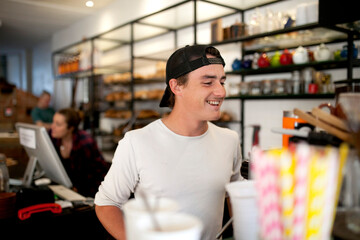 Young male barista working at cafe