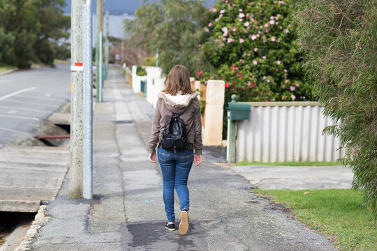 girl walking away along footpath