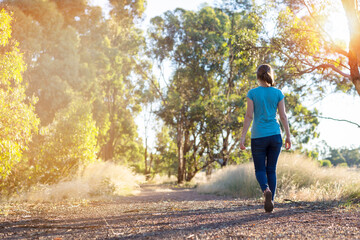Young woman walking away on bush trail