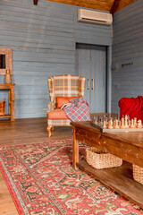 cozy all wooden interior of a country house in a wooden design. spacious living room with kitchen area with large windows. bedroom on the second floor.