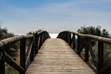 Fototapeta na wymiar long wooden boardwalk and beach access leads to beach and glistening ocean