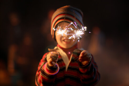 Little boy waving sparklers on a bonfire night
