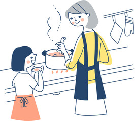 キッチンで調理をする母親と手伝う女の子