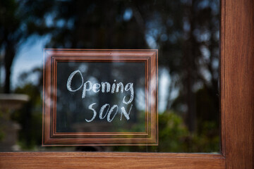 Opening Soon sign on glass shop door
