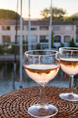 Drinking of local rose wine at sunset with sail boats haven of Port Grimaud on background, Provence, France
