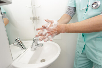 close up of medical staff washing hands