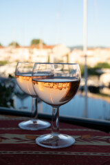 Drinking of local rose wine in summer with sail boats haven of Port Grimaud on background, Provence, France