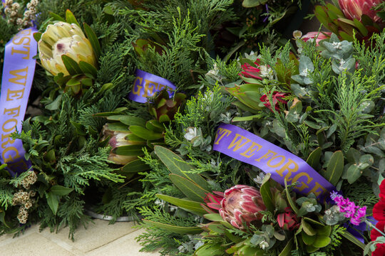 Lest we forget flower wreaths laid beside a memorial