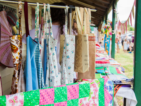 Quilted items and kitchen aprons for sale at a market stall