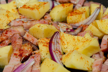 Tyrolean potato specialty. Frying potato with bacon and onion in a pan 