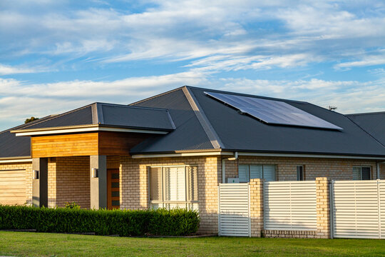 last daylight on front of house with solar panels installed on roof of home