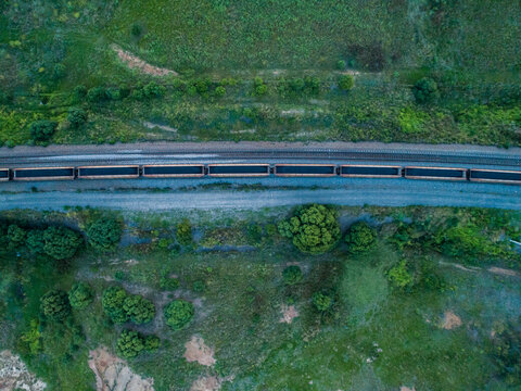 Overhead shot of full coal train passing buy on railway tracks