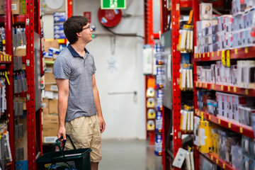 Young man in hardware store shopping for house improvement project