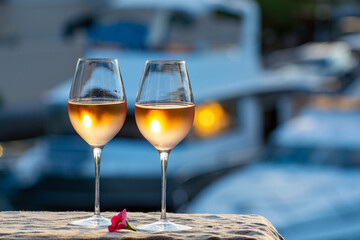 Tasting of local rose wine in summer with sail boats haven of Port Grimaud on background, Provence, France