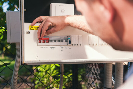 Electrician checking switches at the power box
