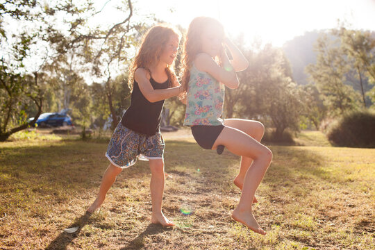 Two Girls Playing On A Swing