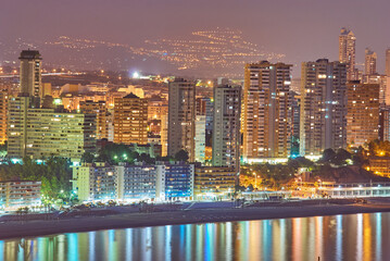 top view of the beach, buildings and illuminations in the evening at Playa de Levante and Playa de Poniente beach in Benidorm, Spain