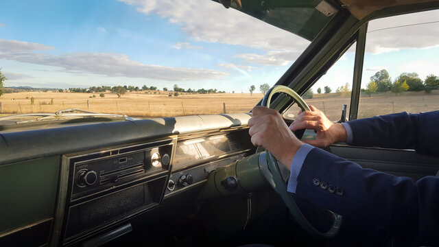 Man driving a classic car (1968 Holden kingswood HK) in the country