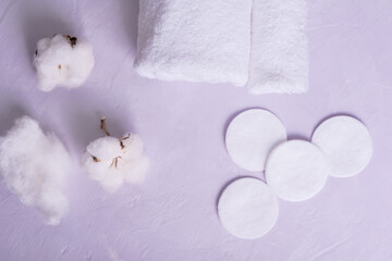 Clean towels, cotton pads  and  cotton flowers on table. Natural cotton fabric texture, top view