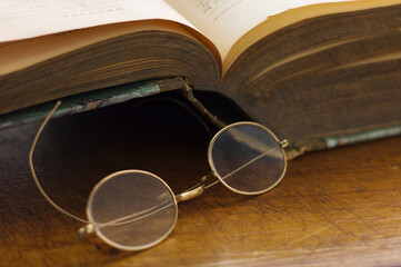 Close up antique round glasses and open book