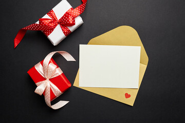 Greeting card mockup and gift box with paper decorations on black background