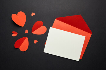 Greeting card mockup with red paper hearts on black background