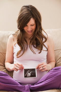 USA, Utah, Lehi, Young pregnant woman looking at CT image of unborn baby