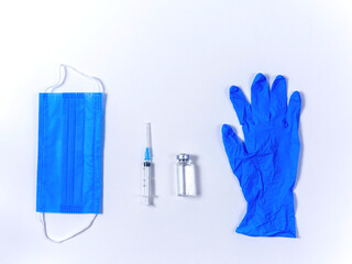Medical flat lay with vaccine bottle, syringe, gloves and protective mask on white background. Vaccination flu, measles, coronavirus, covid-19 concept for human, child, adult, pregnant woman