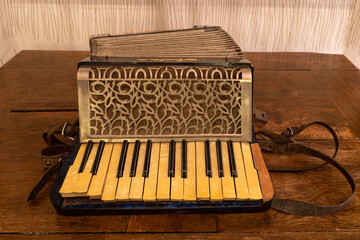 A vintage accordion standing on a wooden table