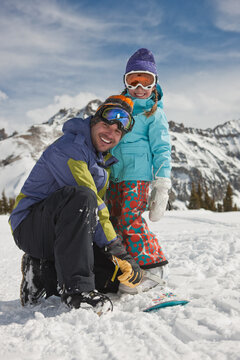 USA, Colorado, Telluride, Father and daughter (10-11) posing with snowboards in winter scenery