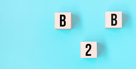 Concept word B2B - business to business on cubes on a beautiful blue background. Business concept. Copy space.