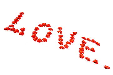 The inscription love is made of red glass hearts. Isolate on a white background.