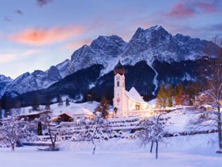 winter sunrise behind beautiful church in the mountains - Grainau village, Bavaria