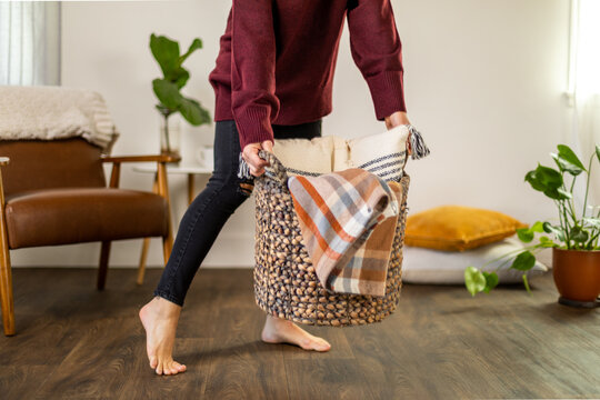 Woman Picks Up Basket in Her Home