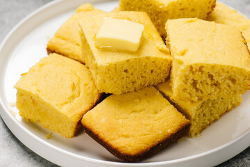 Plate of golden cornbread squares with butter