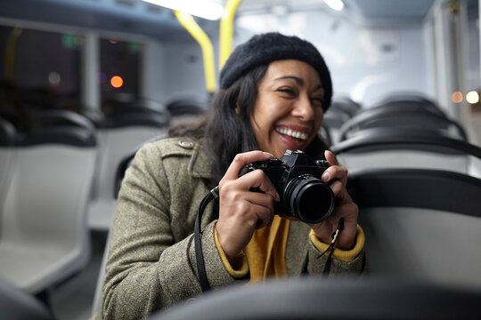 Smiling woman taking photos in a public transportation