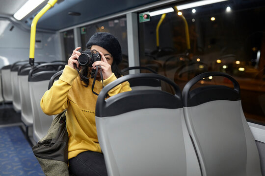 woman taking photos in a public transportation