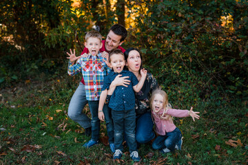 family portrait with mom, dad, brother, sister making silly faces