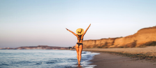 Pretty brunette woman relaxing on the beach at the sea.