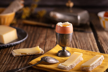 boiled egg in a silver eggcup with bread