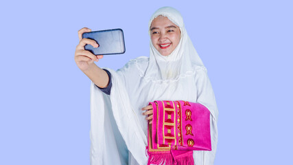Asian Muslim Woman video calling with her family on mobile phone. Ied Mubarak, Ramadan New Normal Concept