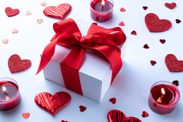 Valentines day background: red love hearts, romantic gift box, candle on white table. February romance present card.