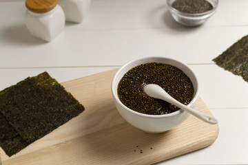 Chia seed appetizer with soy sauce and nori seaweed with ingredients on a white background. Vegetarian food concept. Superfood. Horizontal orientation.