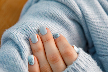 gentle pastel manicure for a girl on a background of clothes