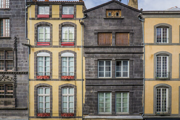 typical facades built with volcanic stones in the clock tower street (Rue de l'horloge), in Riom, a...