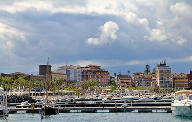 mountain view over the sea, above them a lot of dense white clouds, mountains descending into the...
